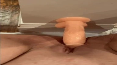 She teases her hungry pussy with a dildo glued to the wall